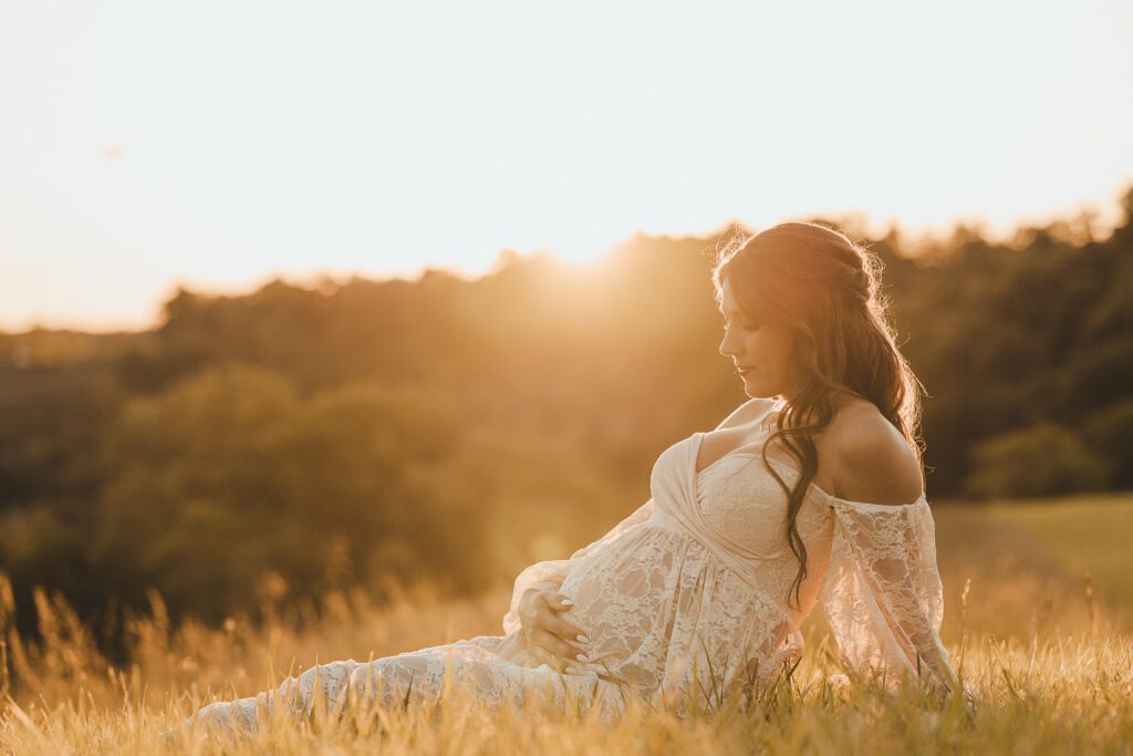 Gorgeous pregnant woman in a field at sunset